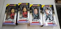 Front view of four boxed Headliners XL 11" hockey figure Chelioses showing packaging and figure inside.