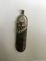 Front view of pendant showing labradorite stone with silver setting, tear drop moonstone and small round amethyst.