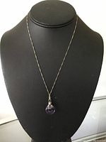 Full front view of the sterling silver necklace with purple agate pendant featuring a bear charm, displayed on black bust.