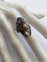Sterling silver ring on mannequin hand showing oval amethyst and crystal point with detailed beadwork.