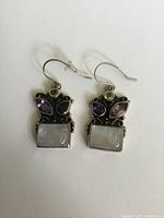 Front view of the earrings showing gemstone layout and silver metal setting.