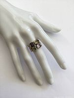 Ring displayed on white mannequin hand showing size and fit on finger.