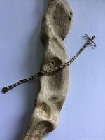 Top view of the tennis bracelet laid on wooden background showing linked triangular settings and clasp.