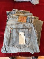 Top view of folded Levi's jeans displaying back pocket and leather patch with size label.