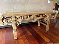 Front view of bench showing rectangular top and carved apron with central circular medallion
