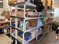 Full view of shelving units containing multiple boxes and items in plastic shelving units