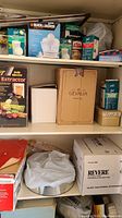 Photo of shelves showing juicers, coffee boxes, plastic wide mouth caps, and kitchenware boxes.