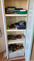 Full cabinet view showing multiple shelves with assorted hand tools including screwdrivers, pliers, and toolboxes.