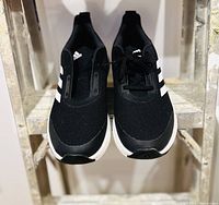 Top frontal view of the Adidas running sneakers showing black upper with Adidas logo and white stripes.