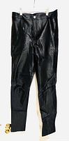 Full view of black shiny leggings hanging, showing front side with button and zipper.