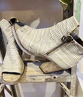 Side view of light grey leather ankle boots showing open toe, zipper and block heel