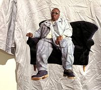 Front view of light lavender T-shirt with prominent graphic print of Biggy Smalls sitting on a black chair.