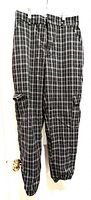 Full front view of Ardene tapered cargo jogger pants in dark grey and white plaid hanging against white background.