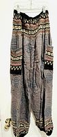Full view of hanging multi-patterned harem pants showing overall design and fit