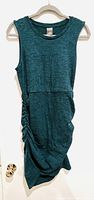Front view of the dark teal sleeveless knit dress hanging, showing overall design and cut.
