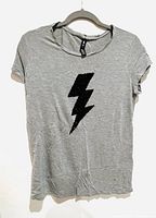Full front view of the light gray H&M T-shirt showing the relaxed fit and sequin lightning bolt detail.