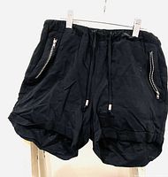 Front view of black Ardene shorts with elastic waistband and zipper pockets