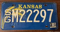 Front view of blue Kansas license plate with embossed white characters GM22297, dated August 1983.