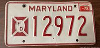 Front view of used Maryland license plate number 12972, dated 1978 with red on white embossed design.