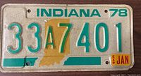 Front side of an Indiana 1978 license plate with embossed green characters and orange state outline