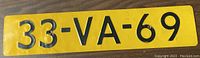 Front view of yellow license plate with black embossed characters '33-VA-69'