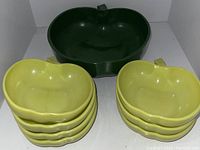 Top angled view showing stacked yellow apple-shaped bowls in front of a large green apple-shaped bowl
