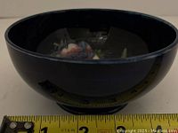Side view of the Moorcroft bowl showing deep blue glaze and floral interior design with measurement tape indicating approximately 6 inch diameter