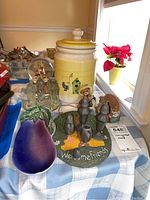 Photo showing the vintage pottery cookie jar, pewter salt and pepper shakers on themed base, two bear figurines, and ceramic leaf dish on a blue checkered cloth under natural window light.