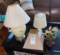 Set of three lamps and one lampshade on black table in living room