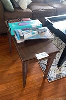 Wooden organ bench showing top surface with scratches and wear, items on top not included.