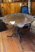 Full view of the wood pie crust table showing its scalloped top and carved details.