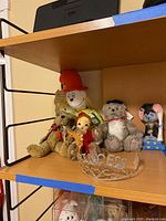 Shelf showing the teddy bears, dolls, ceramic mouse, and princess tiara arranged