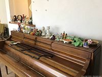 Long view of wooden surface with various animal figurines and miniature ceramics arranged in a line