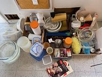 View of all items including Corningware dishes, glass bakeware, plastic food containers, mixer, and utensils grouped on floor.