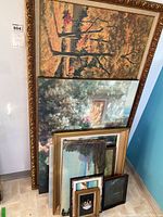 Seven framed and unframed paintings stacked vertically showing various landscapes and art styles.