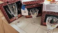 Three boxed sets of European lead crystal stemware including champagne flutes and wine goblets visible on kitchen counter.