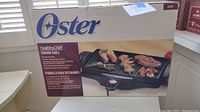 Image of the Oster Healthy Chef Indoor Grill in original packaging showing the box front with product image and branding.