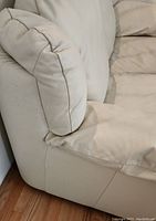 Front left corner view showing armrest, cushion and lower upholstery