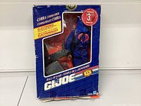 Front view showing the packaged G.I. Joe Cobra Commander action figure with electronic feature label and a $3 rebate sticker.