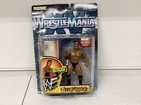 Front view of unopened WWF WrestleMania XII The Rock action figure in plastic bubble on card backing.