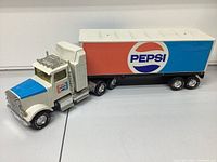 Full side view of the vintage Pepsi semi truck toy showing entire cab and trailer with Pepsi logo.