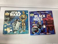 Two children's story books with 33 1/2 RPM records: Star Wars showing R2-D2 and C-3PO on cover, and The Black Hole by Walt Disney Productions.