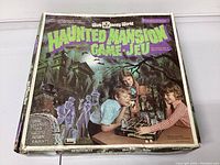 Top view of haunted mansion vintage board game box showing colorful ghostly mansion and children playing game