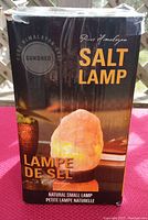 Front of original box packaging showing Pure Himalayan Salt Lamp branding and image of lit salt lamp on wooden base