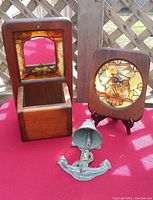 Photo of vintage stained glass owl framed in wood, wooden candle sconce with stained glass and mirror, and cast iron garden anchor bell.
