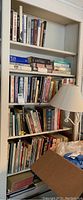 Bookshelf with a mix of hardcover and paperback books, mainly cookbooks and some non-fiction.