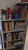 Full view of three shelves displaying a collection of books including reference guides on antiques, collectibles, and art.