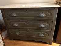 Full front view of wood dresser showing three drawers and marble top