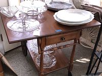 Wood tea cart top view showing drawer and various dishes