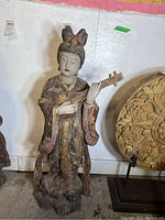 Frontal view of entire statue showing figure and lute